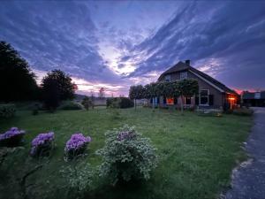 a house with purple flowers in the yard at Erve Zonnehoeve B&B en Wijngaard in Vorden +47 photos