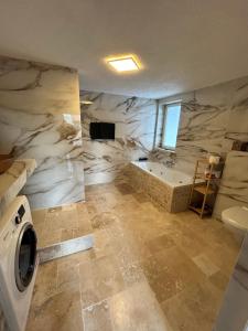 a bathroom with a tub and a washing machine at 2 ZKB 65 m2 komplette Wohnung in Bad Friedrichshall +9 photos