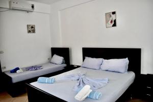 two beds in a room with blue and white sheets at Vila Llaka in Himare