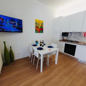 a white kitchen with a white table and chairs at Casa Vacanze ClaEli in Porto SantʼElpidio +71 photos