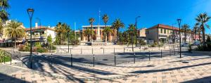 a large plaza with palm trees and a building at Le Mazet d'Azur in La Londe-les-Maures