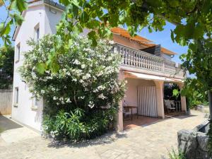 a house with a flowering tree in front of it at Apartment Rose in Krk