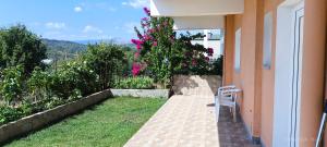 a white chair sitting on a porch of a house at La casa di Voula in Néa Seléfkeia