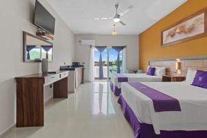 a hotel room with two beds and a television at Hotel Yeah Rinc&oacute;n de Guayabitos in Rincon de Guayabitos