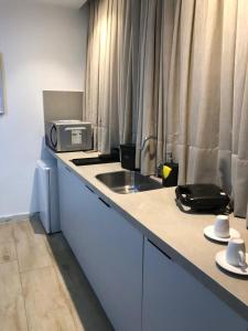 a kitchen counter with a sink and a microwave at Flat Maravilhoso na Praia de Cabo Branco in João Pessoa