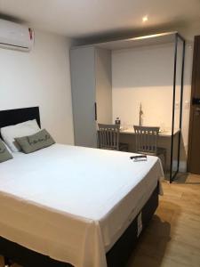a bedroom with a bed and a table and a desk at Flat Maravilhoso na Praia de Cabo Branco in João Pessoa