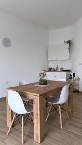 a kitchen with a wooden table and two white chairs at Marina Casa Vacanza in Capoterra