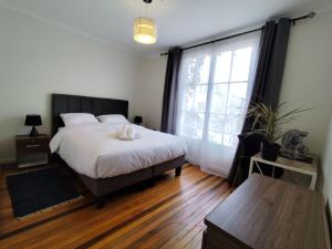 Un dormitorio con una cama y una ventana grande. en Casa CasCal, en Santiago