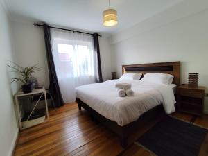 Un dormitorio con una cama con dos animales de peluche encima. en Casa CasCal, en Santiago