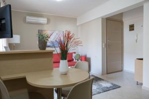 a living room with a table and a red couch at Filora Apartment in the city center in Heraklio Town
