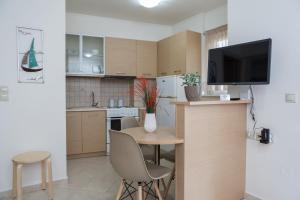 a kitchen with a small table with chairs and a television at Filora Apartment in the city center in Heraklio Town +12 photos