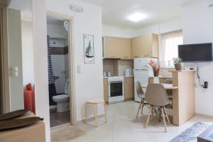 a kitchen and living room with a table and chairs at Filora Apartment in the city center in Heraklio Town
