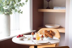 a table with a bowl of bread and a glass of orange juice at Boutique Pastorale in Linschoten