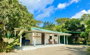 a small white house with a green roof at Casa Del Bambu in Puerto Jiménez