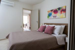 a bedroom with a large bed with pink pillows at Filora Apartment in the city center in Heraklio Town