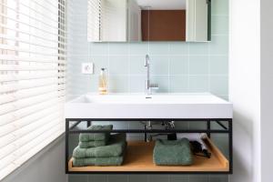 a bathroom with a sink and towels on a shelf at Boutique Pastorale in Linschoten +35 photos