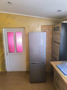 a kitchen with a refrigerator and a white door at Casa de vacanță Anni - 2 min de piață in Eforie Nord