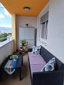 a living room with a couch and a table on a balcony at Apartment CityAna - private garage, 0-24 Self Check In in Zagreb