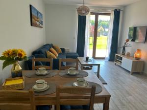 salon ze stołem, krzesłami i kanapą w obiekcie Apartament Łebska Ostoja w mieście Żarnowska