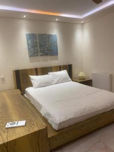 a bedroom with a large bed with white sheets at Efrosinis home in Néa Michanióna
