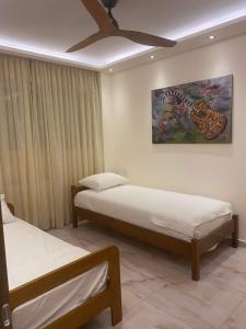 a bedroom with two beds and a painting on the wall at Efrosinis home in Néa Michanióna