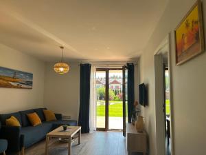 salon z niebieską kanapą i stołem w obiekcie Apartament Łebska Ostoja w mieście Żarnowska