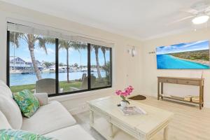 Una sala de estar con un sofá blanco y una mesa. en Sailfish Suites 6 - pet friendly waterfront, en Stuart