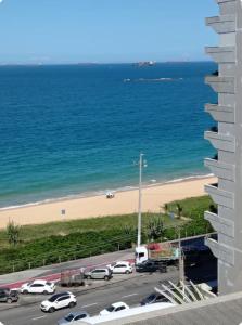 a view of a beach and the ocean from a building at Vista mar sol&mar in Vila Velha