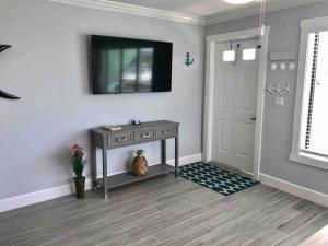 a hallway with a table and a television on a wall at Sailfish Suites - 11 - pet friendly in Stuart