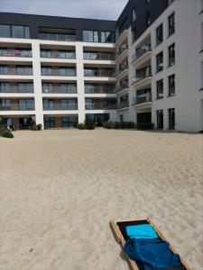a briefcase on the beach in front of a building at Boszkowo Horizon Park apartament 24 in Boszkowo-Letnisko
