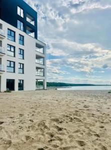 a building on a beach next to the water at Boszkowo Horizon Park apartament 24 in Boszkowo-Letnisko