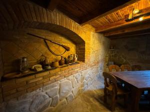 a stone room with a table and a brick wall at Margaliti in Telavi