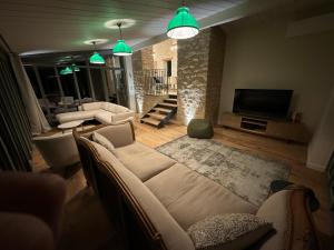 サントネにあるLe Clos de la Chapelleのソファとテレビのあるリビングルーム