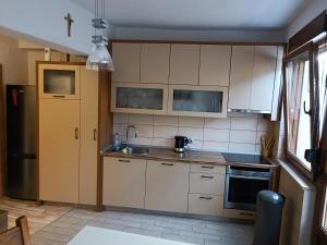 a kitchen with white cabinets and a sink at Apartment Dia in Makarska