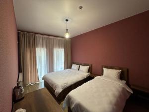 a hotel room with two beds and a window at Margaliti in Telavi