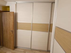 a closet with white cabinets and a wooden door at Apartment Dia in Makarska +3 photos