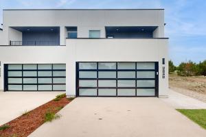 a white house with blue garage doors at Lago Vista Hideaway in Lago Vista