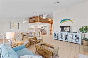 a living room with couches and a table at Sea Pointe on the Canal in Key Colony Beach