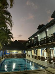 a swimming pool at night with a bridge over it at Pousada Aqui é Para-Ti in Paraty