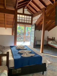 a bedroom with a large bed with blue sheets at Pousada Aqui é Para-Ti in Paraty