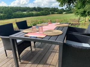 a picnic table with straw hats on a deck at Glamping with outdoor wood-fired hot tub in Vissenbjerg