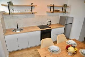 a kitchen with a sink and a table with a bowl of fruit at Apartman Centar in Čapljina