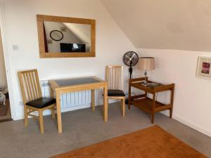a room with a table and two chairs and a mirror at Beach view apartments in Kent