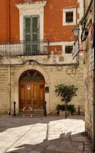 a building with a wooden door and a bench in front at Enza Domus in Bari +20 photos