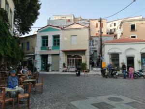 a group of people sitting at tables on a street at Plomari Geometer House in Plomari