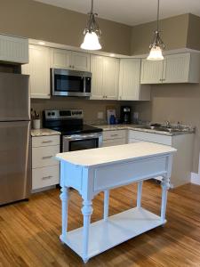 a kitchen with a blue table in the middle of it at Beach House - On Lake Time in Newport