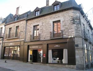 a building on a street with a store at Le Minotel in Vitré