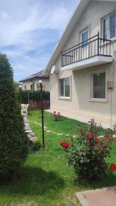 a house with a yard with red flowers in front of it at Casa Silvia - Corbu in Corbu