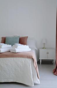 a white bed with white sheets and pillows on it at MAISON ANGELINA - Elegante Casa Vacanze in Puglia con Charme e Comfort in Grumo Appula