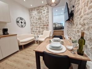 a kitchen and dining room with a wooden table and chairs at Small house Saint Michael in Šibenik